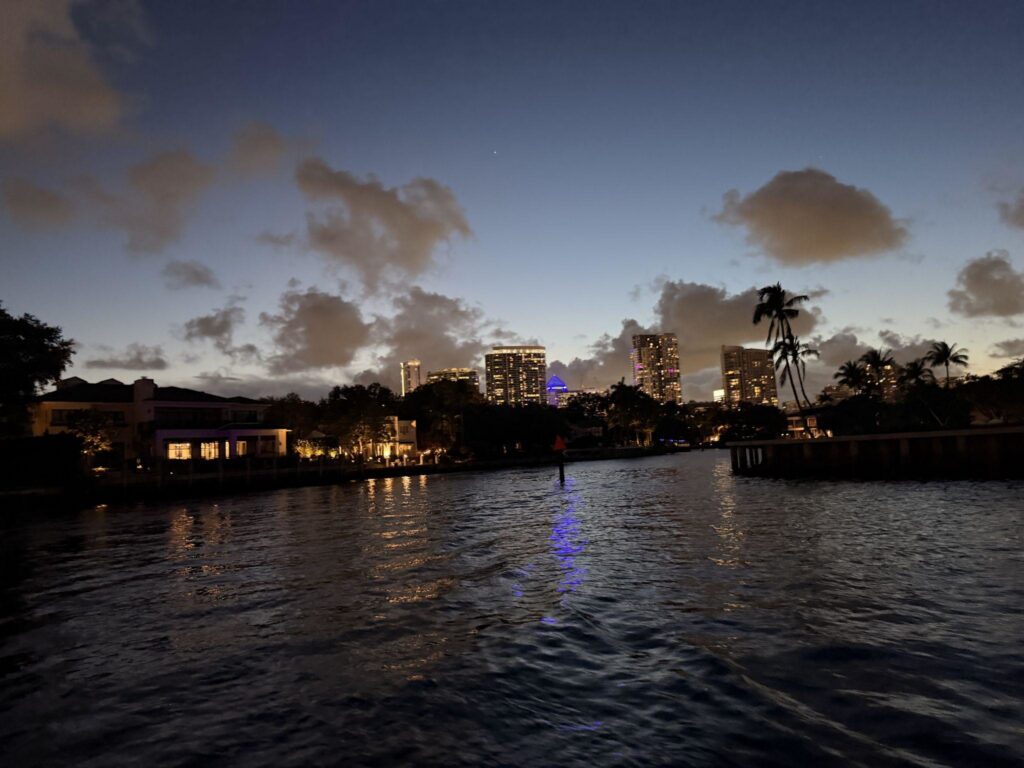 Downtown Fort Lauderdale at dusk from a water taxi - View of the water and downtown skyscrapers with lights on.