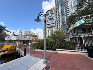 Yellow water taxi docks at a pier with a brick walkway next to a historic home.