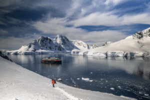MS Roald Amundsen in a polar bay under an open sky. 